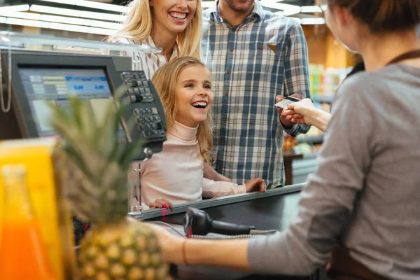 Familia alegre pagando con tarjeta de crédito —  Fotos de Stock