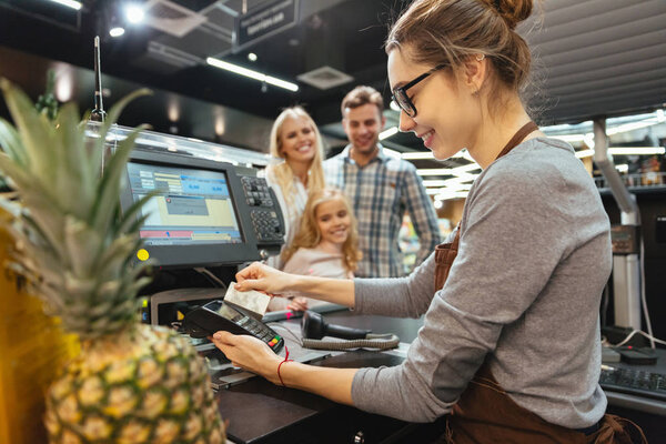 Happy family paying for their groceries