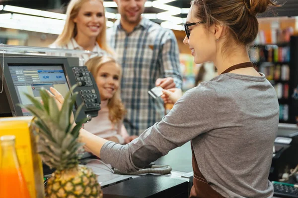 Smiling family paying for their groceries — Stock Photo, Image
