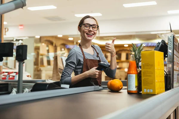 Bastante hembra cajero escaneando artículos de comestibles —  Fotos de Stock