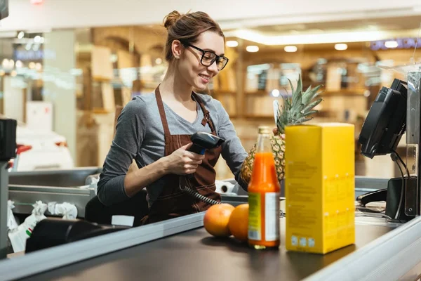 Smiling cashier perempuan memindai barang belanjaan Stok Lukisan  