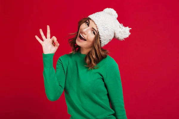 Щаслива брюнетка в светрі і смішний капелюх показує добре — стокове фото