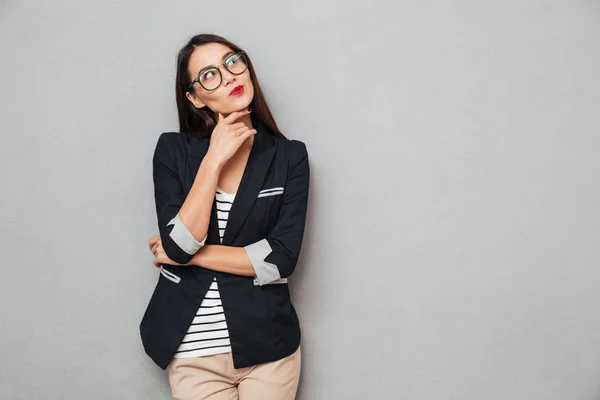 Kuva Pensive aasialainen liike nainen silmälasit etsii ylös — kuvapankkivalokuva
