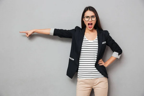 Enojado asiático mujer de negocios en gafas con brazo en la cadera —  Fotos de Stock