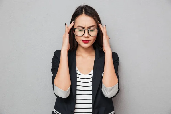 Imagen de mujer de negocios asiática confusa en gafas con dolor de cabeza —  Fotos de Stock