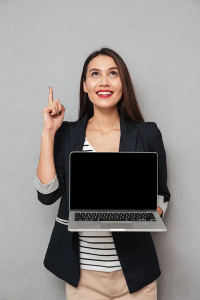 Imagen vertical de la mujer sonriente que muestra la pantalla del ordenador portátil en blanco —  Fotos de Stock