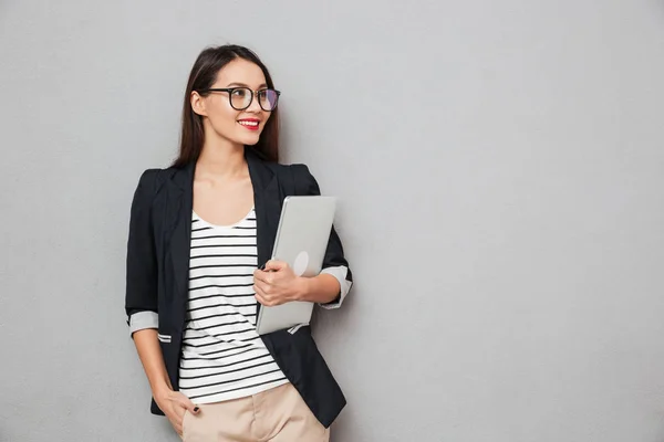 Улыбающаяся азиатская деловая женщина в очках, держащая ноутбук — стоковое фото