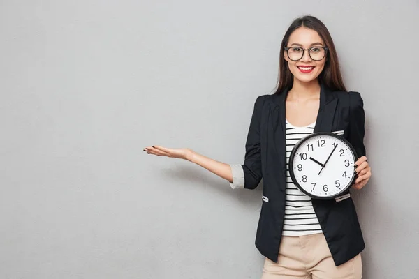 Усміхнена азіатська бізнес-леді в окулярах з годинником тримає копійку — стокове фото