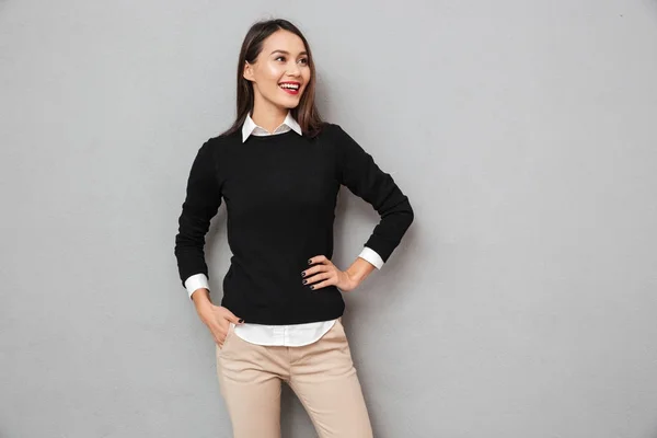 Heureuse femme asiatique en vêtements d'affaires avec bras sur la hanche — Photo