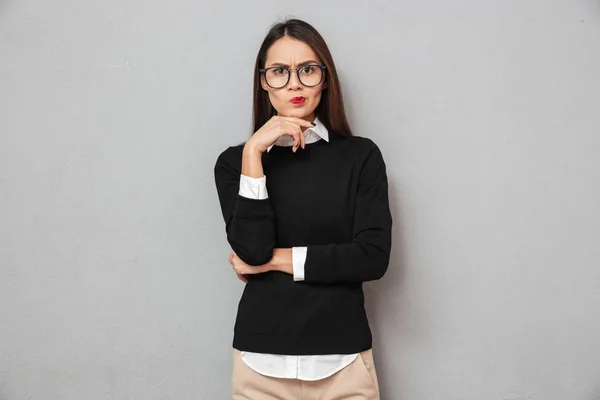 Серьёзная задумчивая азиатка в деловой одежде и очках — стоковое фото