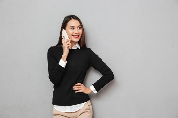 Sonriendo mujer asiática en ropa de negocios con el brazo en la cadera — Foto de Stock