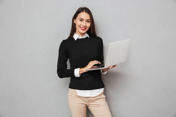 Sorridente donna asiatica in abiti da lavoro utilizzando computer portatile — Foto Stock