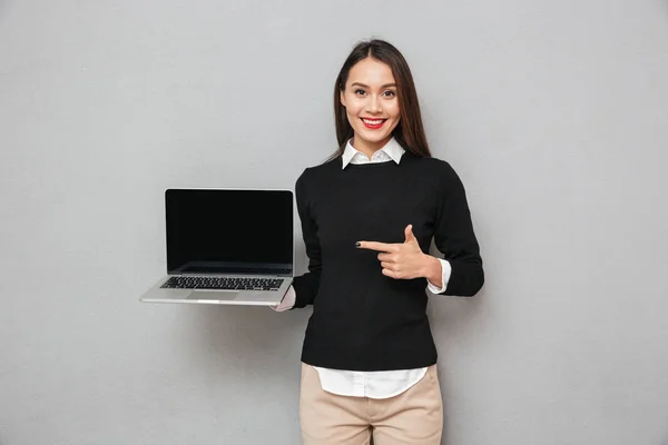Ευχαριστημένος γυναίκα σε επαγγελματικά ρούχα δείχνουν οθόνη κενό φορητού υπολογιστή — Φωτογραφία Αρχείου