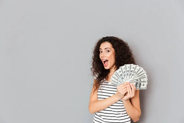 Mulher linda em t-shirt listrada segurando fã de nota de 100 dólares — Fotografia de Stock