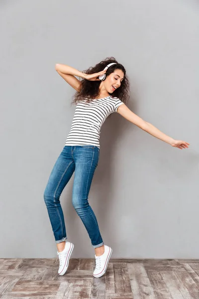 Повнорозмірний вигляд дивовижної леді в смугастій футболці та джинсах — стокове фото