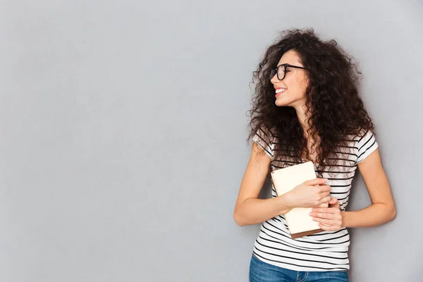 H 本を保持している眼鏡でスマートの笑顔の女性の肖像画 — ストック写真