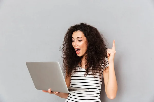 Emotional lady with curly hair holding silver notebook finding u — Stock Photo, Image