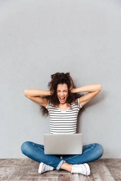 Picture of woman sitting with legs crossed on the floor screamin — Stock Photo, Image