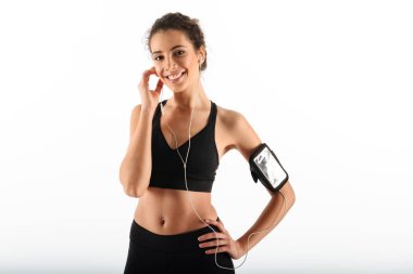 Kol kalça üzerinde tutan mutlu kıvırcık esmer fitness kadın