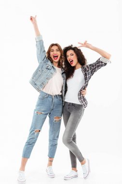 Full length image of two joyful girls standing together