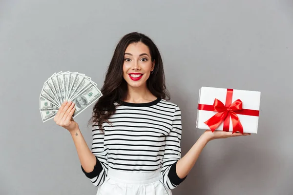 Portrait of a satisfied woman holding gift box — Stock Photo, Image