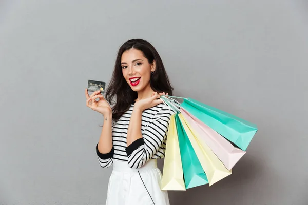 Portrait of a joyful woman showing credit card