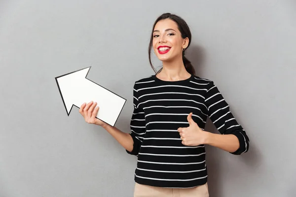 Portrait of a satisfied woman pointing away — Stock Photo, Image