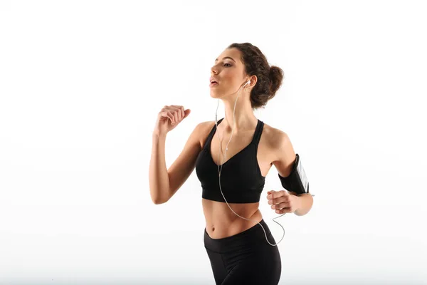 Geballte lockige brünette Fitness-Frau läuft im Studio — Stockfoto
