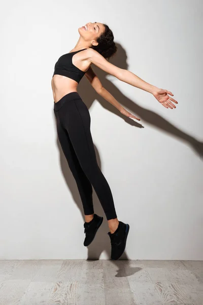 Full-length side view image of pretty curly brunette fitness woman — Stock Photo, Image