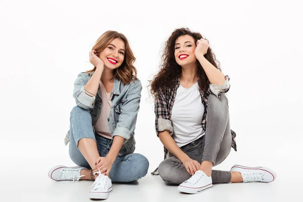 Dos chicas felices sentadas juntas en el suelo —  Fotos de Stock