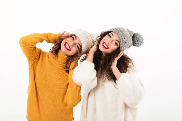 Duas meninas felizes em camisolas e chapéus se divertindo juntos — Fotografia de Stock