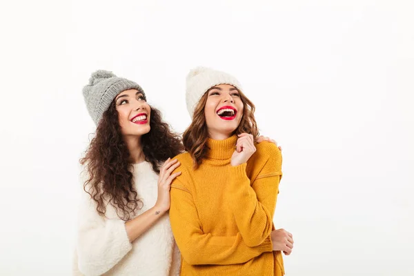 Duas garotas rindo de camisolas e chapéus juntos — Fotografia de Stock