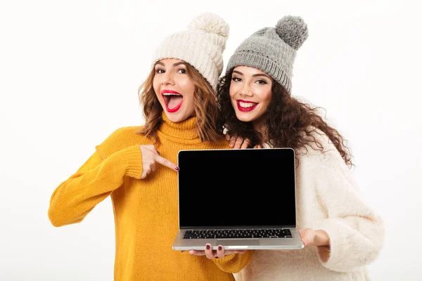 Dvě veselé dívky v svetry a čepice stojí dohromady — Stock fotografie