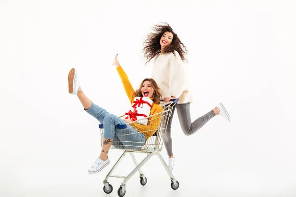 Dos chicas en suéteres divirtiéndose junto con cajas de regalos — Foto de Stock