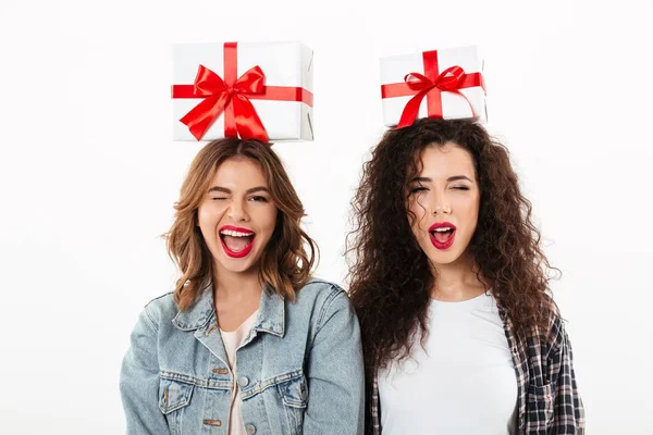Зображення двох щасливих дівчат, що тримають подарунки на голові — стокове фото