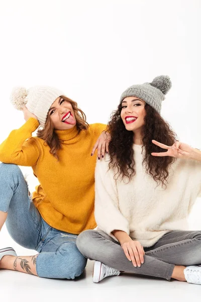 Immagine verticale di due ragazze divertenti in maglioni e cappelli — Foto Stock