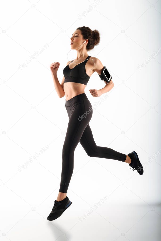 Full length image of Young curly brunette fitness woman running