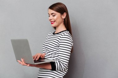 Dizüstü bilgisayar kullanan mutlu bir kadın portresi