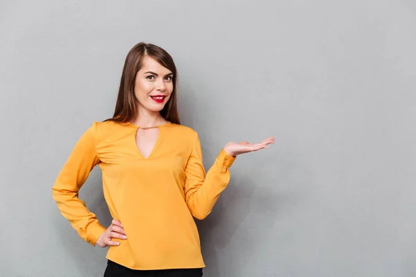 Retrato de uma mulher sorridente segurando espaço de cópia — Fotografia de Stock