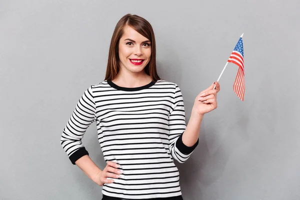 Retrato de uma mulher feliz segurando bandeira americana — Fotografia de Stock