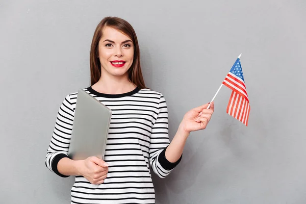 Retrato de una mujer confiada sosteniendo bandera americana —  Fotos de Stock