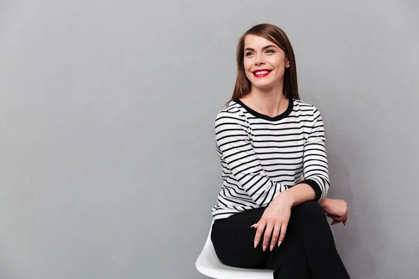 Портрет усміхненої жінки, що сидить на стільці — стокове фото