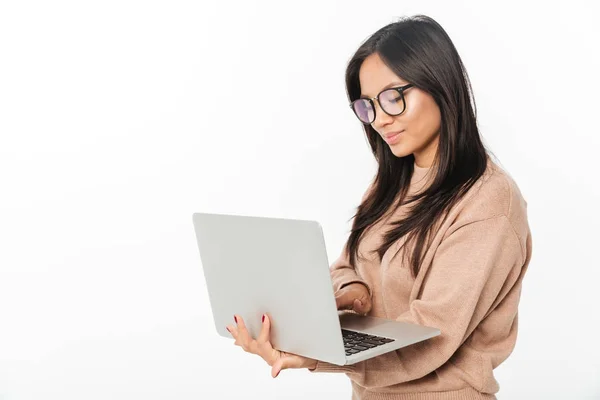 Asian smiling woman wearing glasses using laptop — Stock Photo, Image