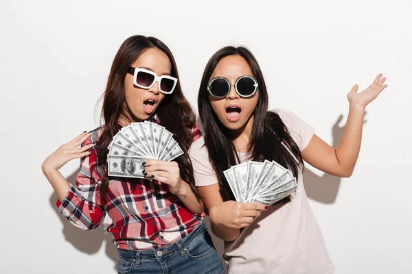 两个亚洲酷女姐妹拿着钱. — 图库照片