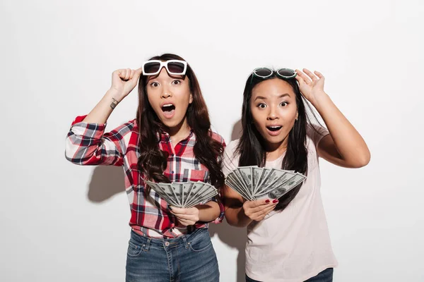 Dos asiático bastante shocked lindo señoras celebración de dinero . —  Fotos de Stock