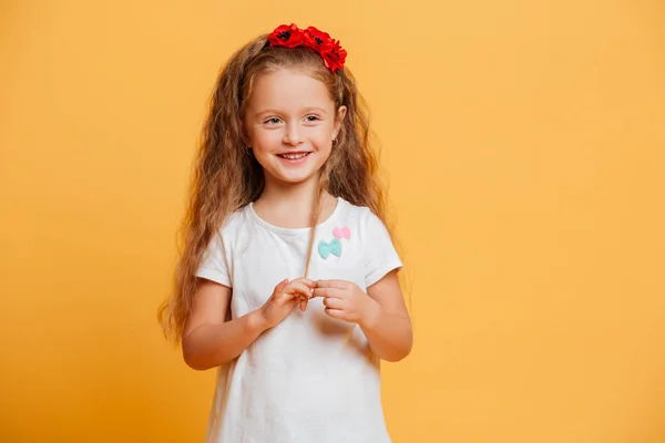 Gelukkig klein meisje kind permanent geïsoleerde over geel — Stockfoto