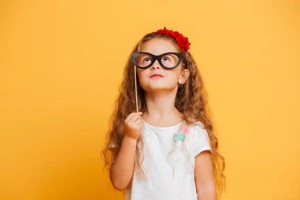 Αστείο, μικρό παιδί κορίτσι εκμετάλλευση πλαστά γυαλιά αναζητούν στην άκρη. — Φωτογραφία Αρχείου