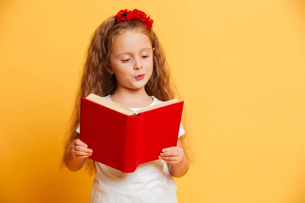 Συμπυκνωμένο μικρό όμορφο κορίτσι ανάγνωση βιβλίων ψάχνει στην άκρη. — Φωτογραφία Αρχείου