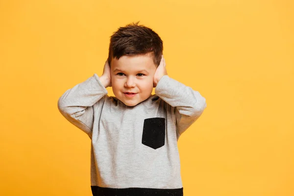 Little boy child standing isolated covering ears with hands. — Stock Photo, Image