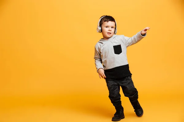少年に立って、子ども孤立ヘッドフォンで音楽を聴く. — ストック写真